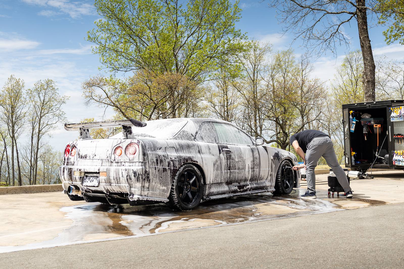 Car covered in snow foam on the wash pad during a decontamination wash