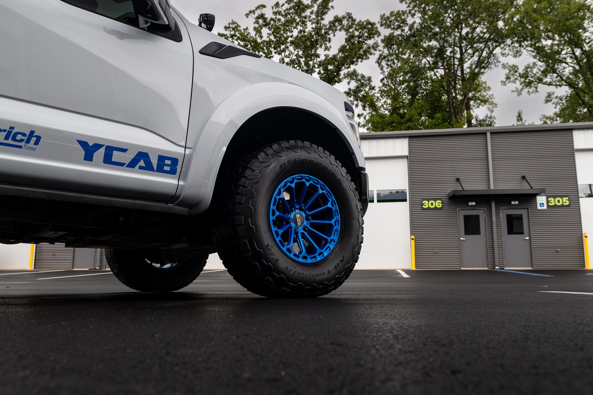 Ford Raptor with custom wheels outside the shop