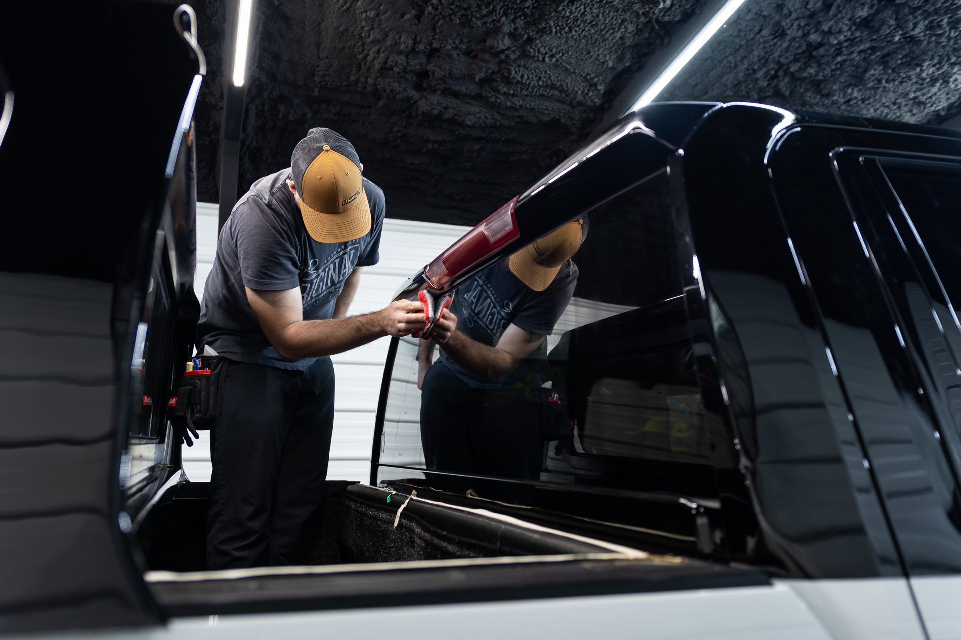 Team installing window tint together in the studio